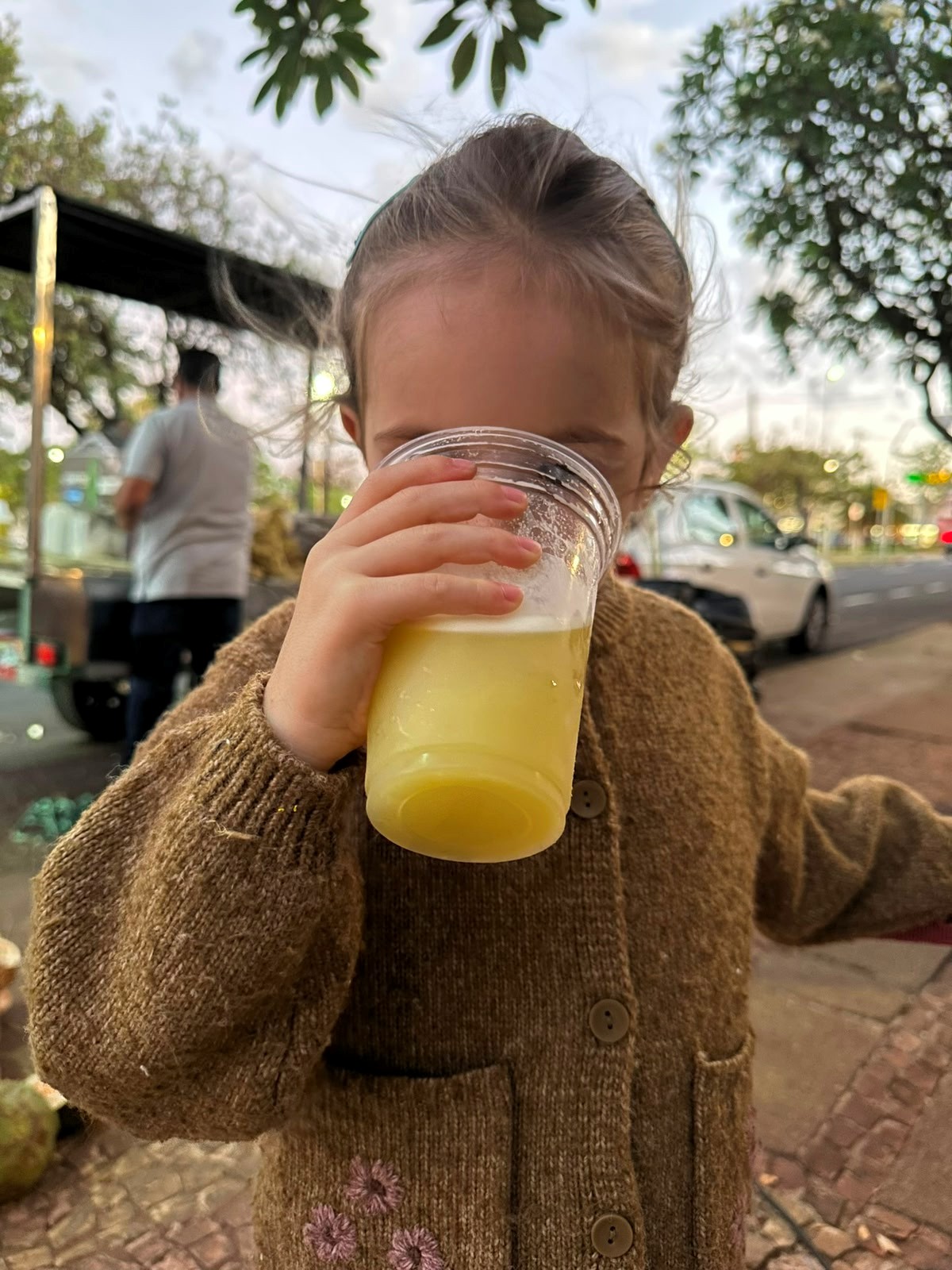 A filha da Liana tomando caldo de cana na rua